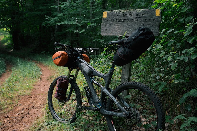 mountain bike resting on sign in the woods