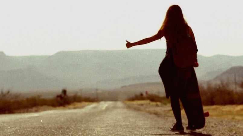 woman hitchhiking on desert road
