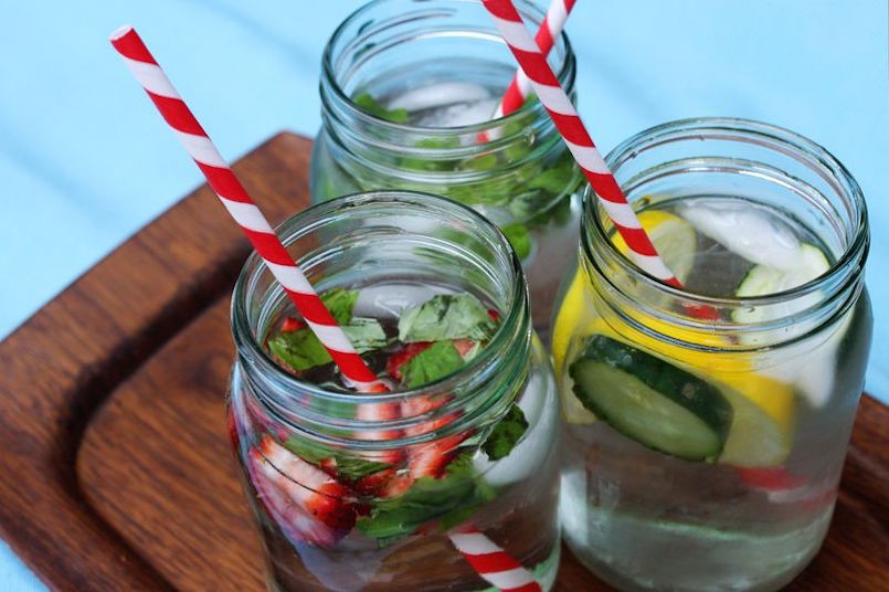 infused water in mason jars with red and white straws