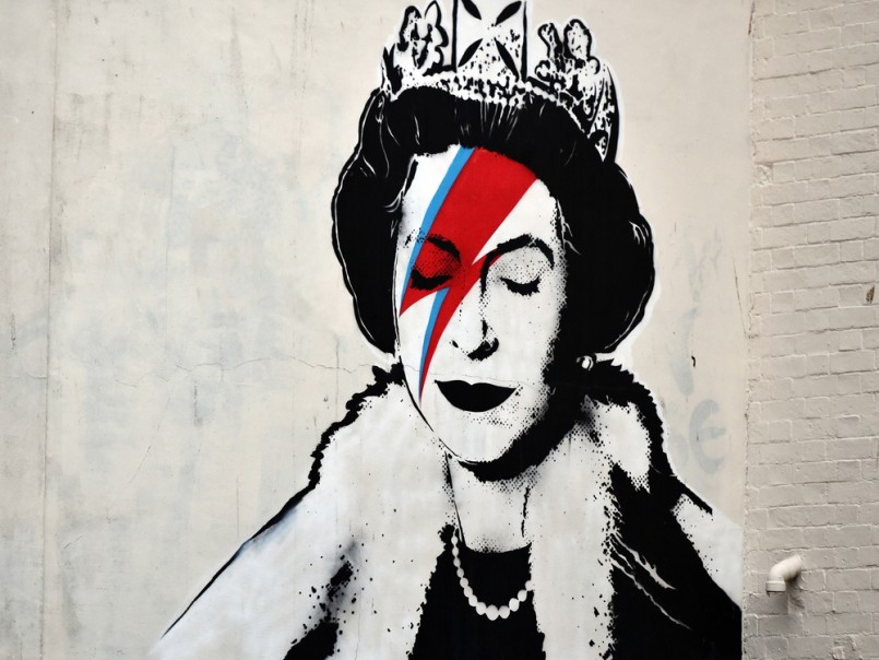 View of a Banksy piece depicting the Queen as David Bowie in his Ziggy Stardust persona seen on a city centre street