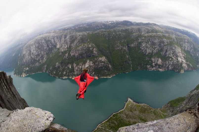 BASE jumper jumping off a big cliff in Norway with a red windsuit, breathtaking