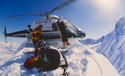Snowboarder Esben Pedersen being dropped of by helicopter onf an isolated peak in the Chugach Mountains