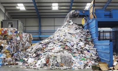 Waste falling on pile from conveyor belt at recycling factory
