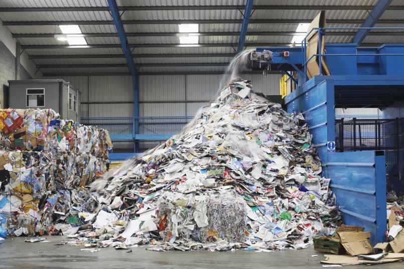 Waste falling on pile from conveyor belt at recycling factory