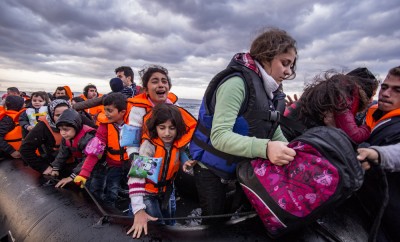 yrian migrants : refugees arrive from Turkey on boat through sea with cold water near Molyvos, Lesbos on an overload dinghy. Leaving Syria that has war