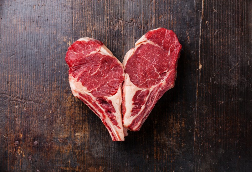 Heart shape Raw meat Ribeye steak entrecote on wooden background