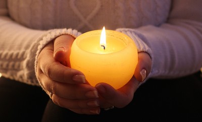 burning candle in the hands of a girl christmas candles